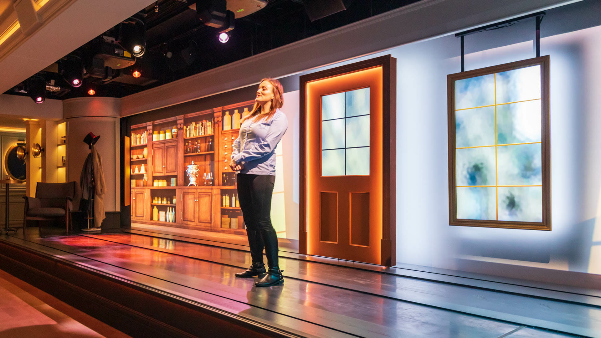 A woman stands on the stage in the Johnnie Walker Experience. With changing backdrops behind her, she tells the story of the whisky maker.