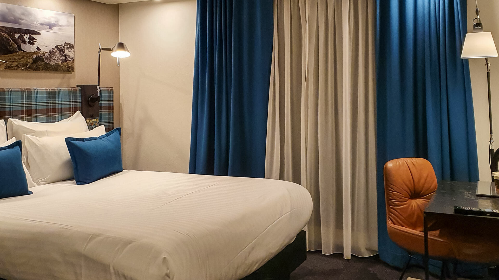 A view of a room at Motel One. With a bed and curtains.