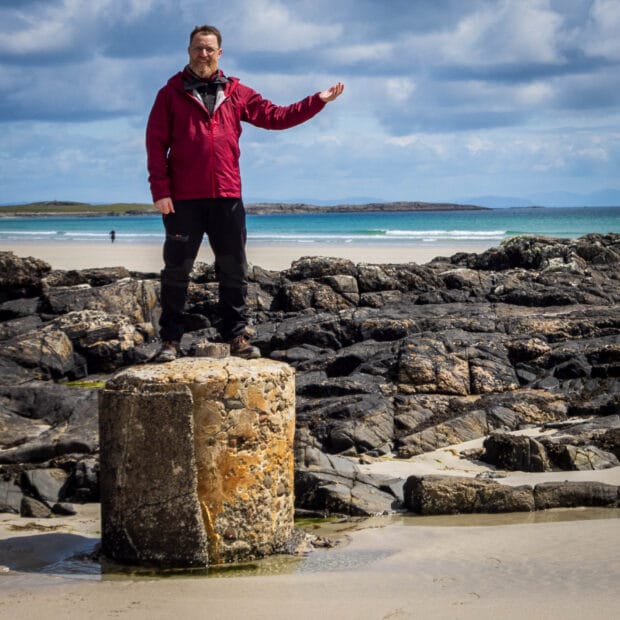 Eine Person auf einem Betonpodest an einem Strand auf Tiree 