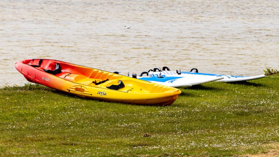 Diverse Wassersport Boards liegen auf ener Wiese