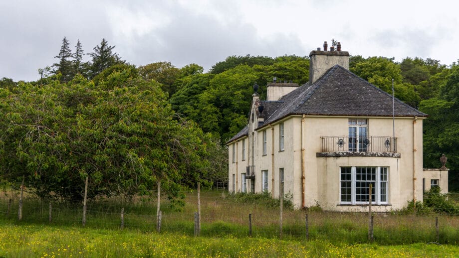 Ein großes Herrenhaus, das umgeben von einer nicht gemähten Wiese unbewohnt auf Ulva steht