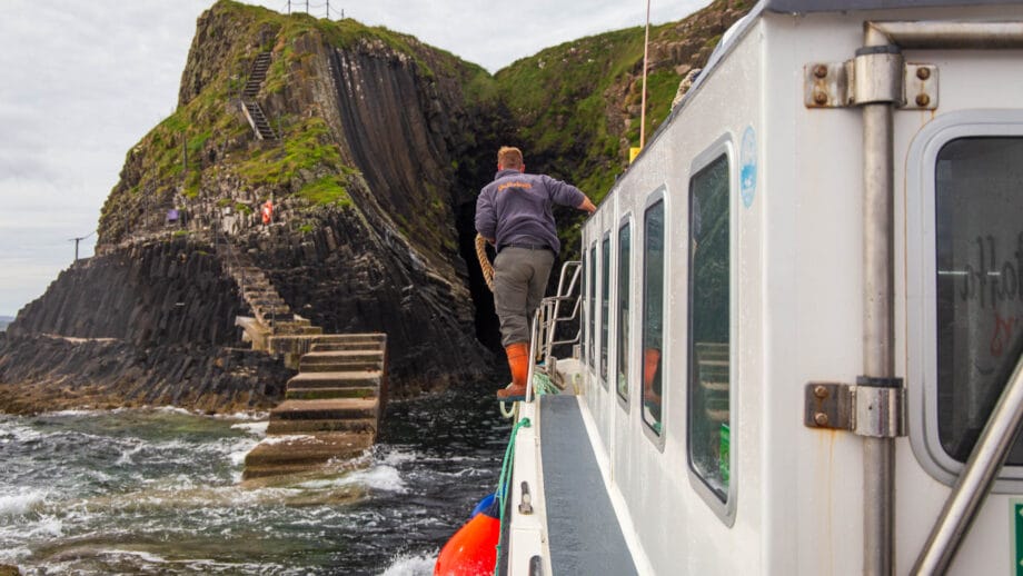 Ein Mitarbeiter von Staffa Tours bereitet das Anlegen am Pier von Staffa vor