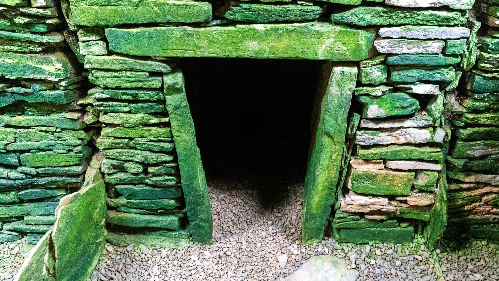 A dark entrance leads to one of the side chambers of Unstan's burial mound.