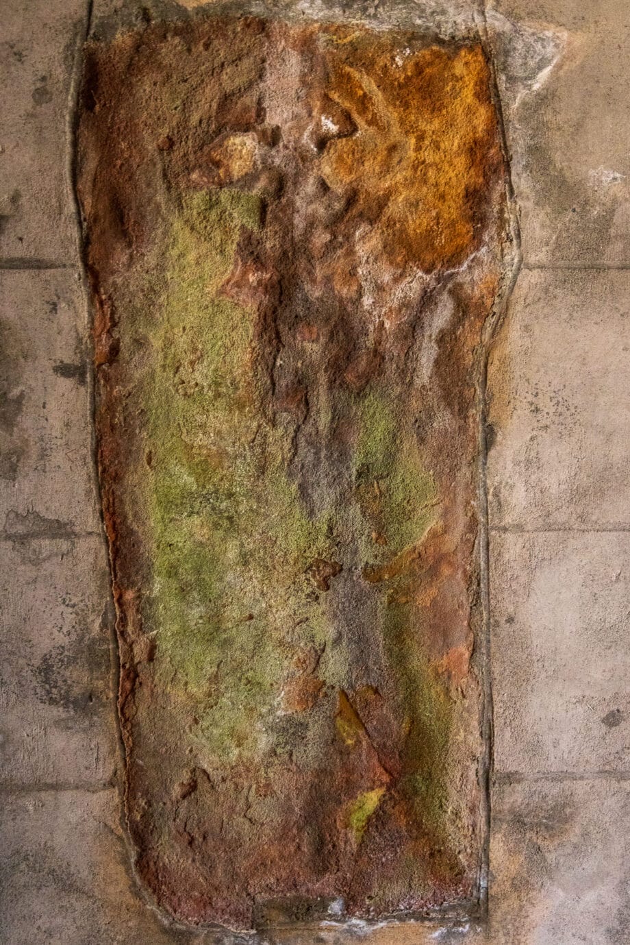 Ein keltisches Kreuz, das alt und verwittert ist, wurde in die Wand der St Kilda’s Church gemauert